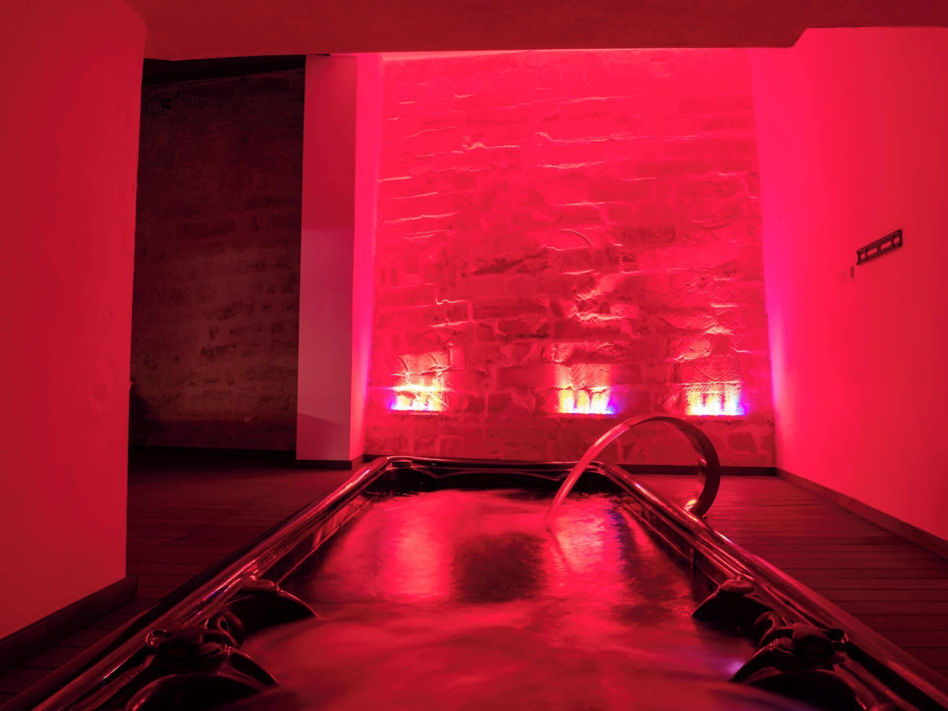 Una sauna con pared de piedra y suelo de madera.