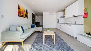 A modern living room with a sofa, a coffee table, and a patterned rug. - Stunning Penthouse Apartment With Private Terrace (Gzira)