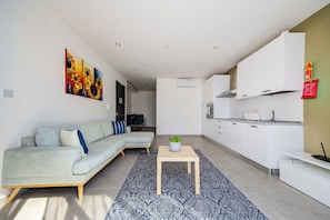A modern living room with a sofa, a coffee table, and a patterned rug. - Stunning Penthouse Apartment With Private Terrace (Gzira)