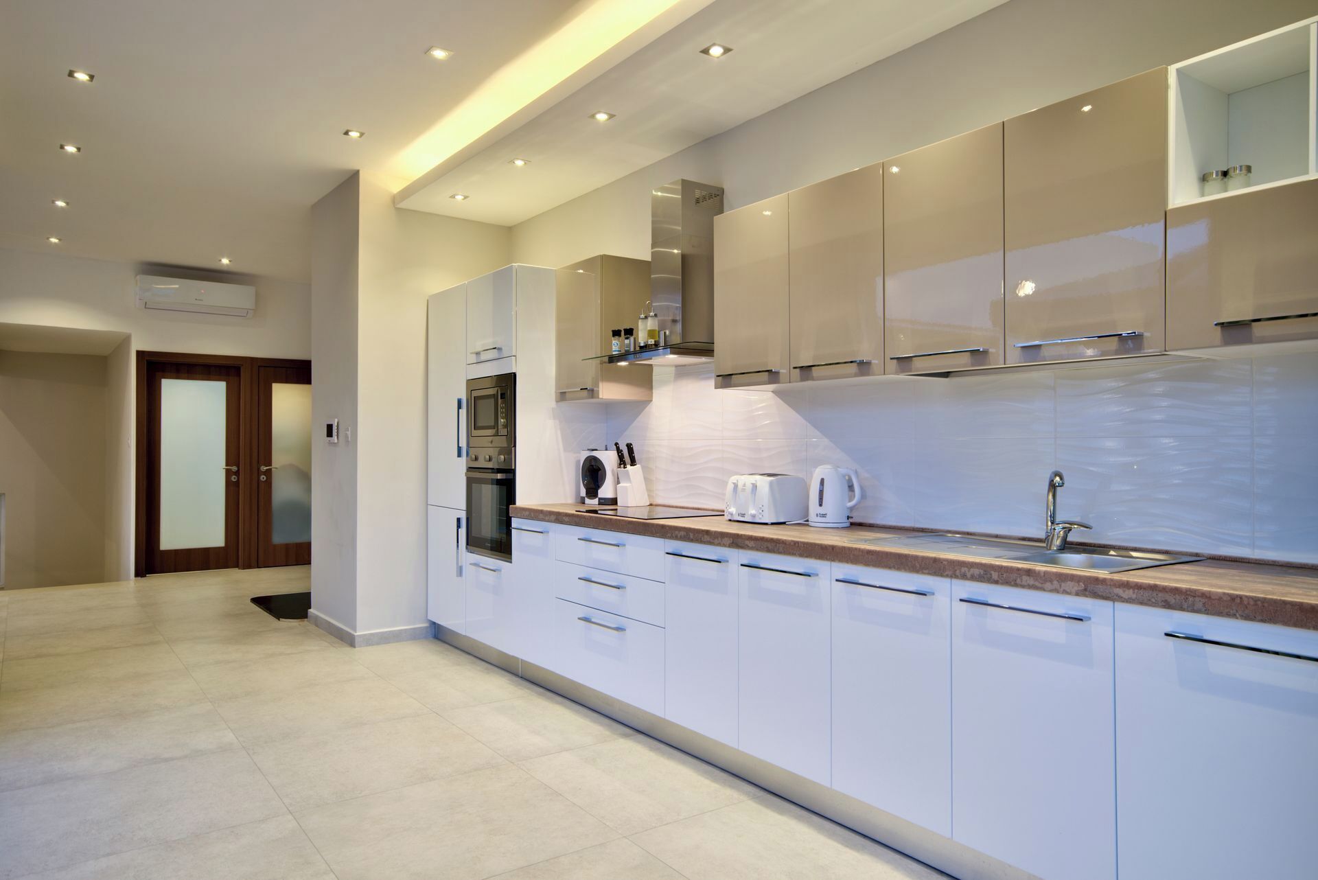 A modern kitchen with white cabinets, stainless steel appliances, and a granite countertop.