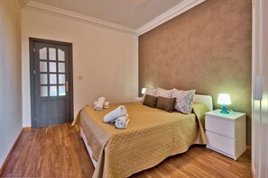 A neatly arranged bedroom with a bed, bedside tables, and a door. - Stunning Home Overlooking Valletta City Skyline (Sliema)