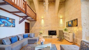 A living room with a sofa set, a coffee table, and a fireplace. - Enchanting Stone Villa With Pool and Jacuzzi (Valletta)