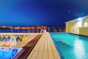 A wooden deck with a pool, lounge chairs, and a hot tub. - Enchanting Stone Villa With Pool and Jacuzzi (Valletta)