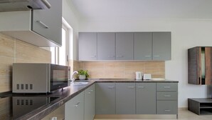 A modern kitchen with grey cabinets, a built-in microwave, and a sink. - Airy Top Floor Apartment With Stunning Terrace (St. Julian's)