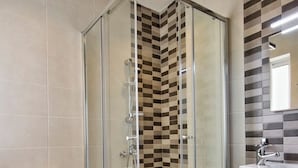 A modern bathroom with a glass-enclosed shower, a toilet, and a sink with a mirror. - Off the Strand Gzira 3-bedroom Apartment (Gzira)