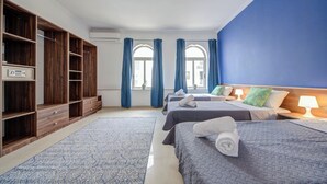 A hotel room with two beds, a wardrobe, and a view of the outside. - Magnificent Minimal Apartment Close to Attractions (St. Julian's)