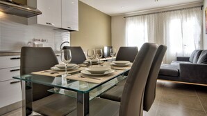 A modern dining area with a glass table, leather chairs, and a sofa in the background. - Amazing Airy Apartment Surrounded by All Amenities (Gzira)