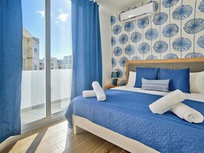 A hotel room with a large bed, a wooden headboard, a view through a sliding door, and a patterned wall. - Amazing Duplex Penthouse With Jacuzzi and BBQ (Sliema)