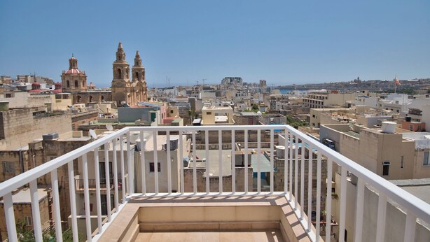 A cityscape with a prominent church and a clear view of the sea. - Stunning City Views Sliema Duplex Penthouse (Sliema)