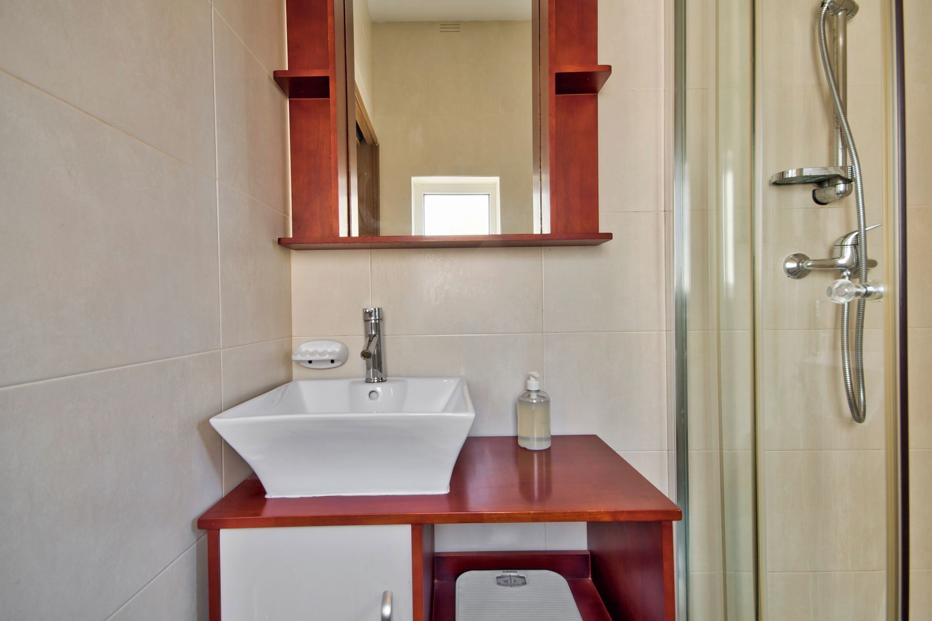 A bathroom with a white sink, a mirror, and a shower.