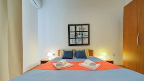 A hotel room with a bed, two bedside tables with lamps, a wall-mounted artwork, and a wardrobe. - Spacious High Ceiling Sliema Apartment (Sliema)