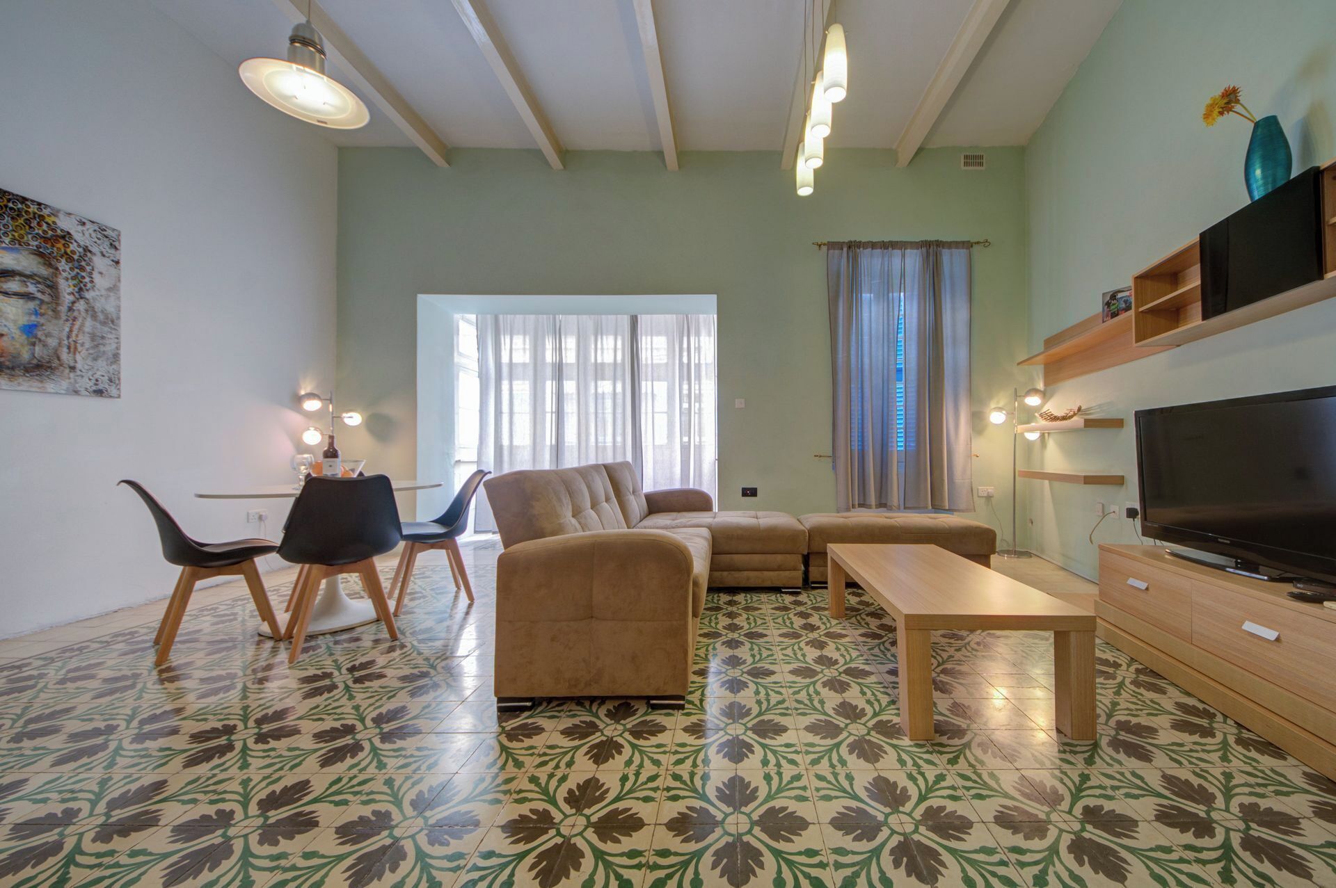 A living room with a sofa, chairs, a TV, and a dining area with a table and chairs.
