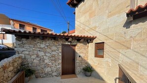 A stone building with a tiled roof, a wooden door, and a small window. - Apartment with shared swimming pool, Sta. (Baiona)