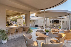 An outdoor bar area with seating and a pool. - Malia Odyssey Adults Only by Estia (Malia)