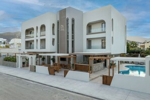 A modern hotel with a pool, outdoor seating, and a mountain view. - Malia Odyssey Adults Only by Estia (Malia)
