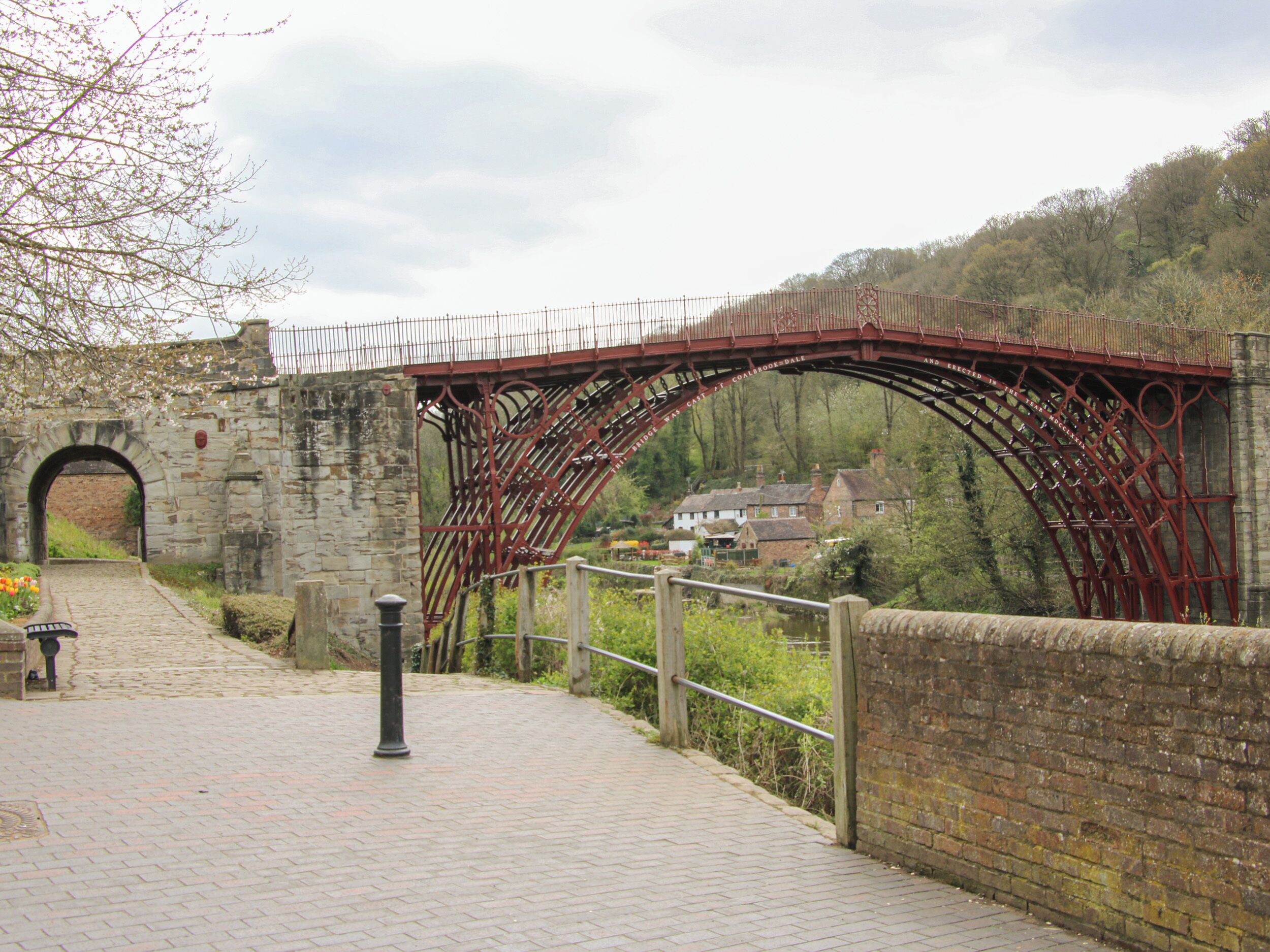 A stone arch bridge with a metal walkway.