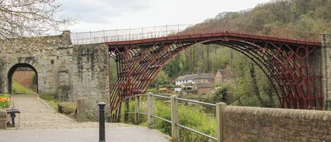 A stone arch bridge with a metal walkway.
