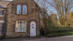 A stone building with two arched windows and a white door. - 1 Rosedale Abbey (Pickering)