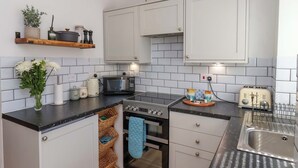 A modern kitchen with white cabinets, a black countertop, a microwave, a toaster, and a sink. - 1 Rosedale Abbey (Pickering)