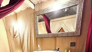 Une salle de bain avec des toilettes, un lavabo et un miroir.