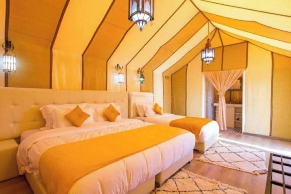 Une chambre avec deux lits, une grande fenêtre et une vue sur l’extérieur.