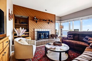 Ein Wohnzimmer mit Kamin, einer Couch, einem Couchtisch und einem Fernseher.
