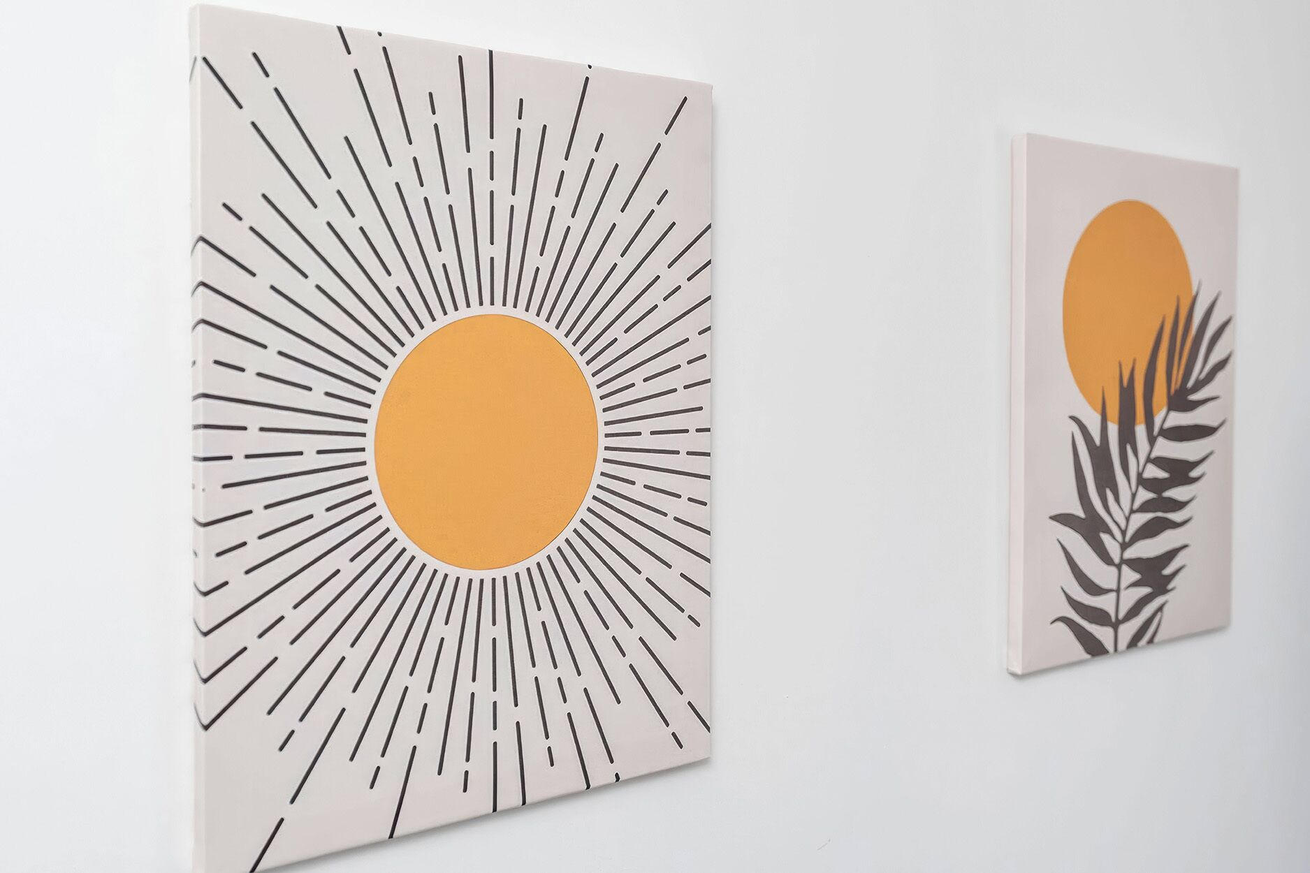 Duas obras de arte com designs abstratos, uma apresentando um círculo central com linhas radiais e outra com um círculo central e padrões semelhantes a folhas.