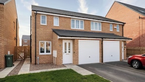 A two-story residential building with a garage, a front door, and a driveway. - 59 Eagle Drive (Grimsby)