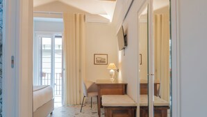 Een kamer met een houten plafond, een bed, een bureau, een stoel en een grote spiegel.