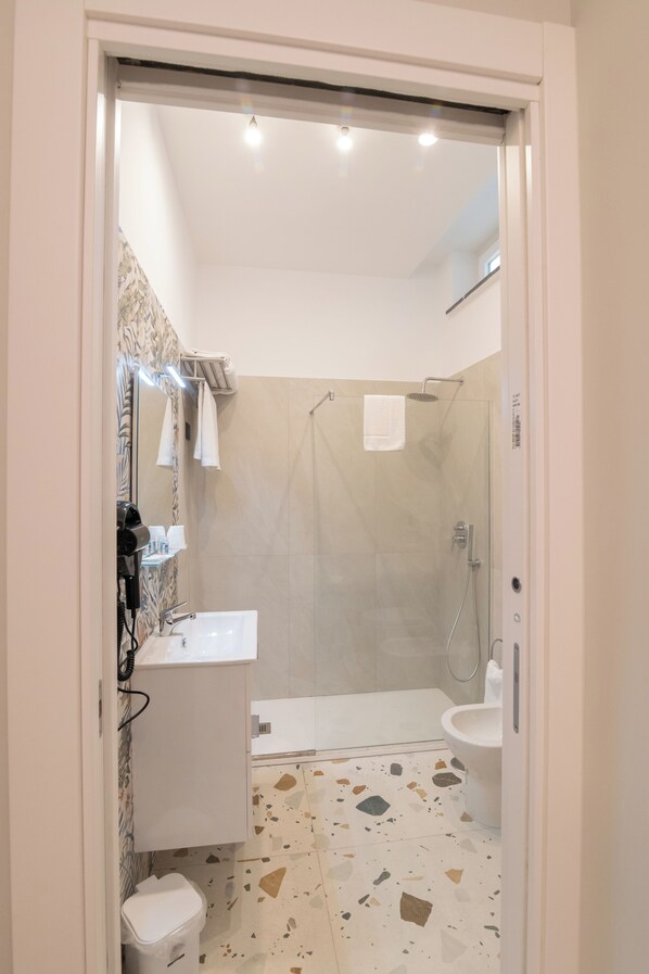 A bathroom with a shower, sink, and toilet.