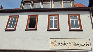 A building with a sign reading 'Wirtshaus am Lehmarkt' and multiple windows with wooden frames. - "Saskia" Vacation Rental with a Beautiful View of the Old Town and a Rooftop Terrace! (Hammelburg)