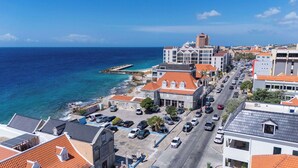 A coastal town with buildings, a road, and a pier. - Home Pietermaai in Willemstad (Willemstad)