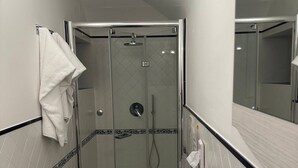 A compact bathroom with a glass-enclosed shower, a toilet, and a sink. - Rifugio con Terrazza Panoramica a Positano (Positano)