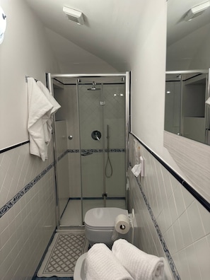 Ein kleines Badezimmer mit einer Duschkabine, Toilette und Waschbecken.