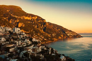 A coastal town with buildings nestled against a hillside, overlooking the sea. - Rifugio con Terrazza Panoramica a Positano (Positano)