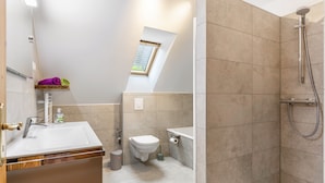 Une salle de bain moderne équipée d’une douche, de toilettes et d’un lavabo.