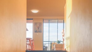 A room with a large window, a painting on the wall, and a chair. - Stunning Downtown Retreat With City Views (Surry Hills)