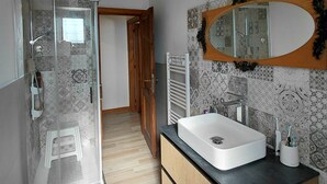 A modern bathroom with a glass shower enclosure, a large mirror, and a wooden vanity. - Il Peppolo Country House  (Pelago)