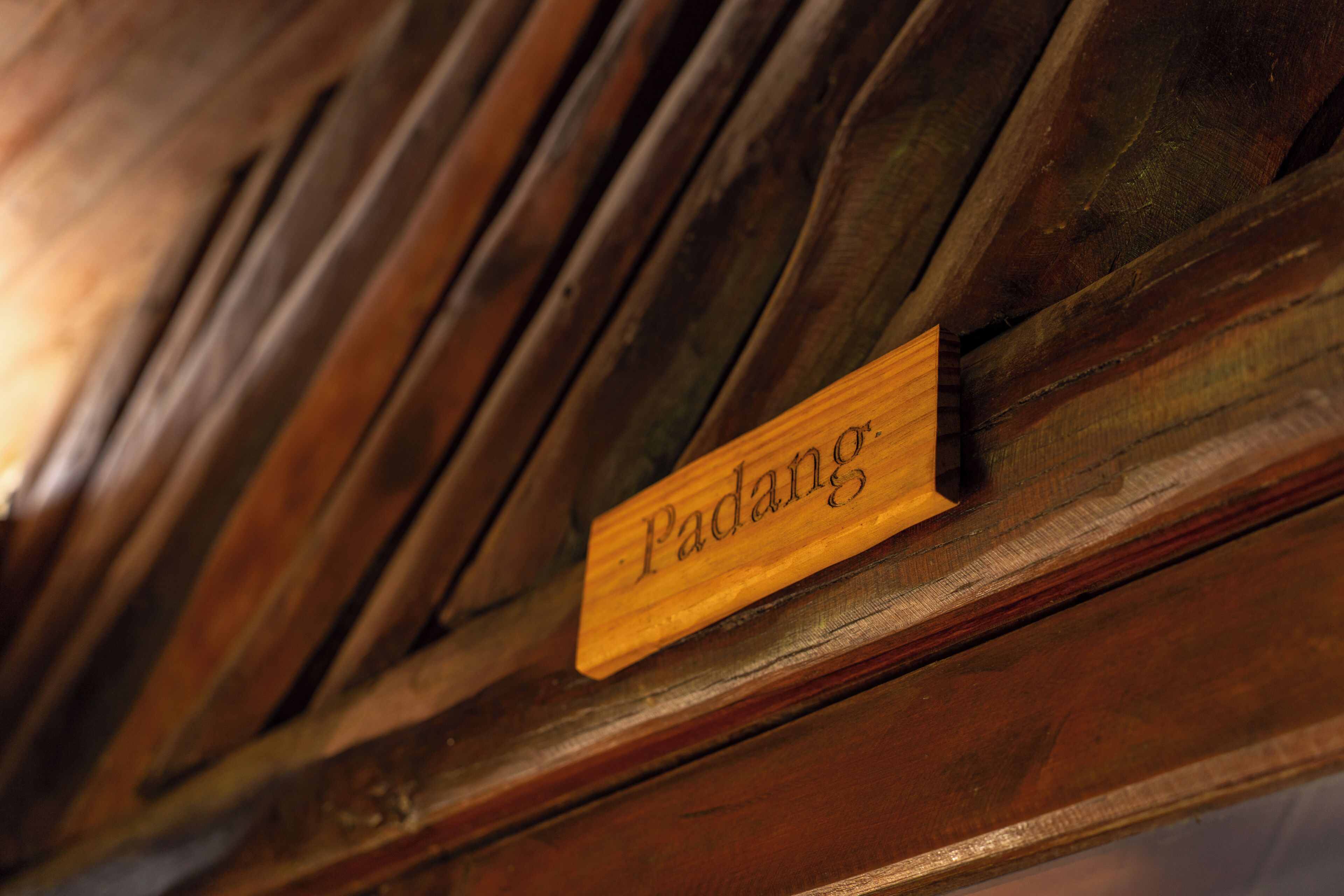 Un letrero de madera con la palabra 'Padang'.