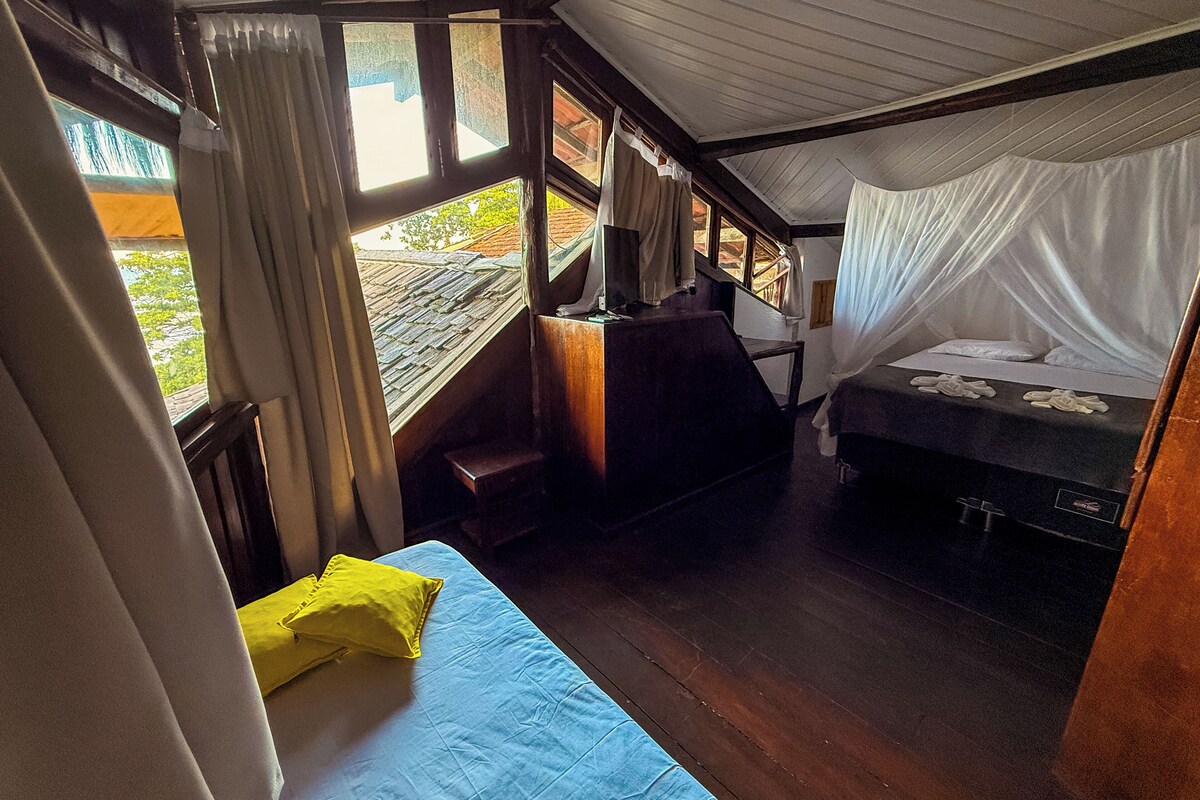 A room with a bed, a small table, and a window with curtains.