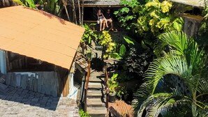 A rural village with traditional wooden houses, a paved pathway, and lush greenery. - Beach House NATUREZA (Itacare)