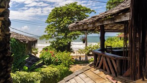 A wooden deck with a view of the beach and ocean. - Beach House NATUREZA (Itacare)