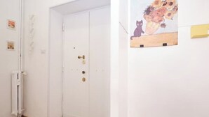 A white door with a brass handle and a radiator on the wall. - [Centocelle - Happy Domus] Oasis of the Sun (Roma)