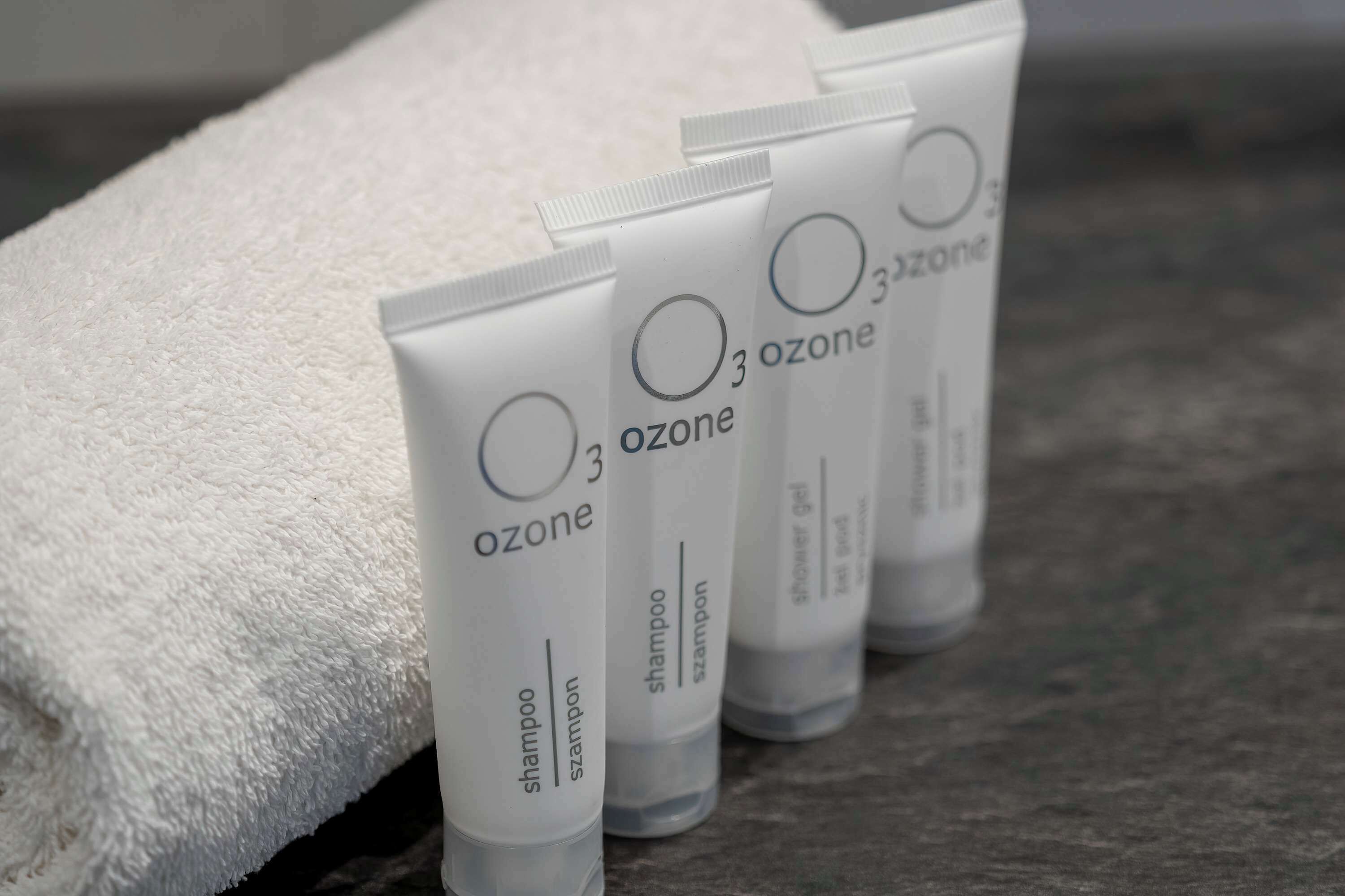 Four tubes of 3 ozone shampoo and shower gel on a textured surface.