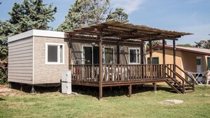Una casa mobile con un patio in legno e un portico coperto.