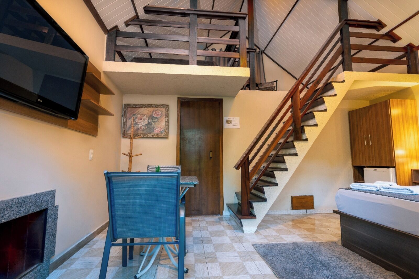 A modern interior with a dining area, a staircase, and a flat-screen TV.