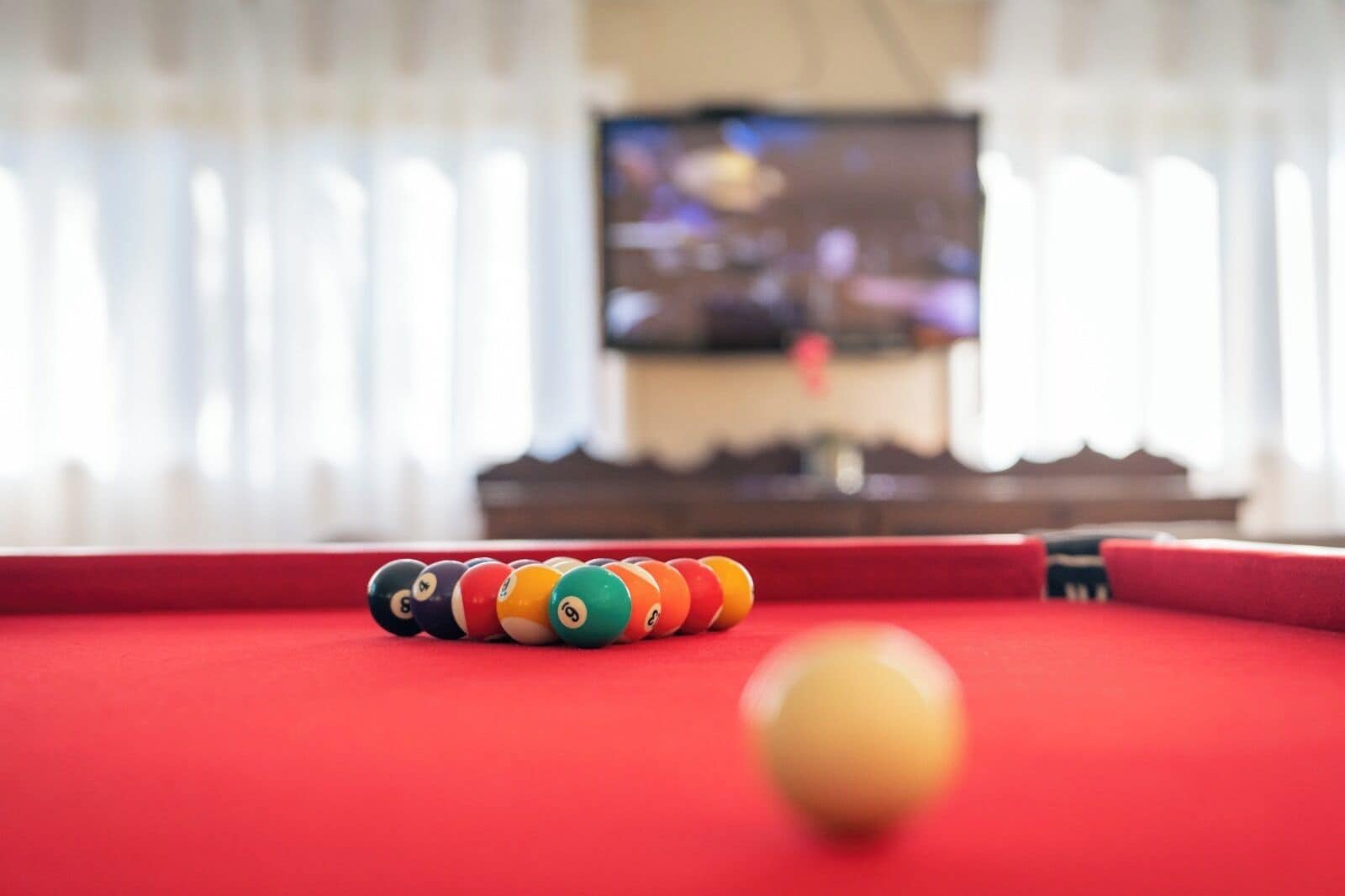 Une table de billard avec un porte-billes rayé et une seule bille blanche.