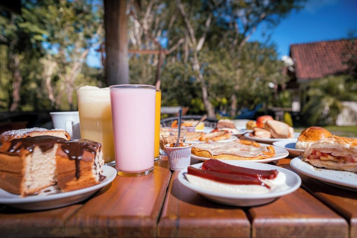 A picnic table with various food items and drinks.