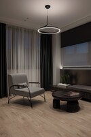 Una sala moderna con un sofá, una mesa redonda de centro, una silla y un televisor.