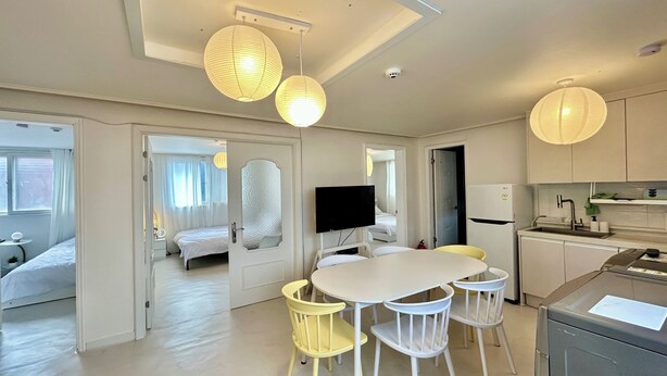 A modern hotel room with a dining area, a television, and a kitchen. - Gangnam Style Village (Seoul)
